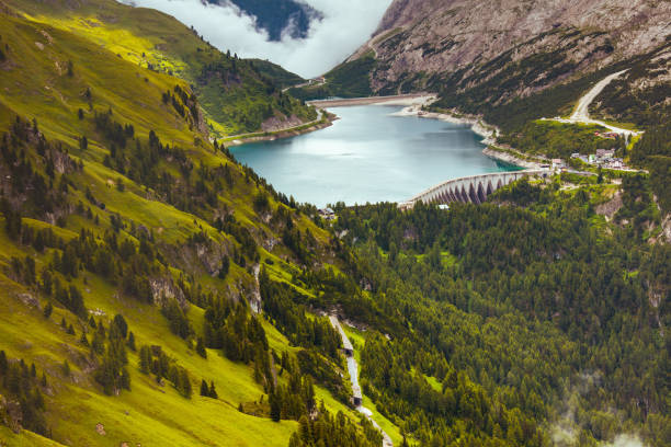 paysage avec des collines, le lac fedaia et la forêt - water surface european alps mountain valley photos et images de collection