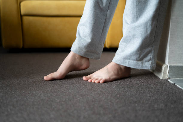istock A close-up view shows bare feet standing on a carpeted floor, likely indicating the warmth from a heating system in a residential setting. 1939687510