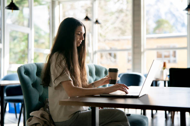 istock A woman is seated at a table in a workshop, engrossed in her work as she uses a laptop. 1939690235