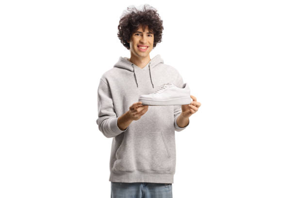 istock Happy young man holding a white sneaker 1939702075