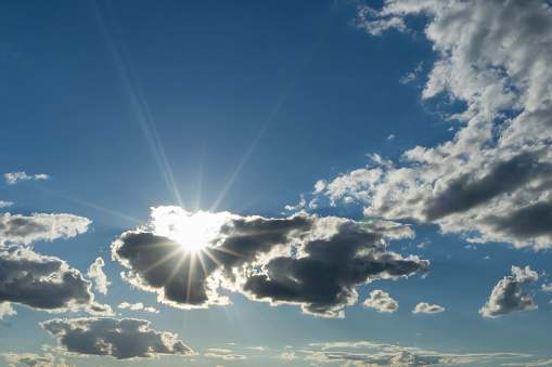 Bright sun over blue sky and clouds with clouds