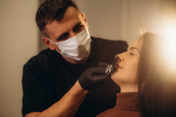 istock Experienced plastic surgeon consulting beautiful woman while using calipers 1939707817