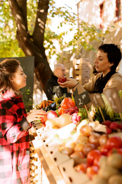 istock Farmer shows organic apples to client 1939708905