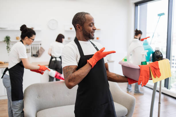 istock American man professional cleaning worker pointing on bucket with detergents. 1939715445