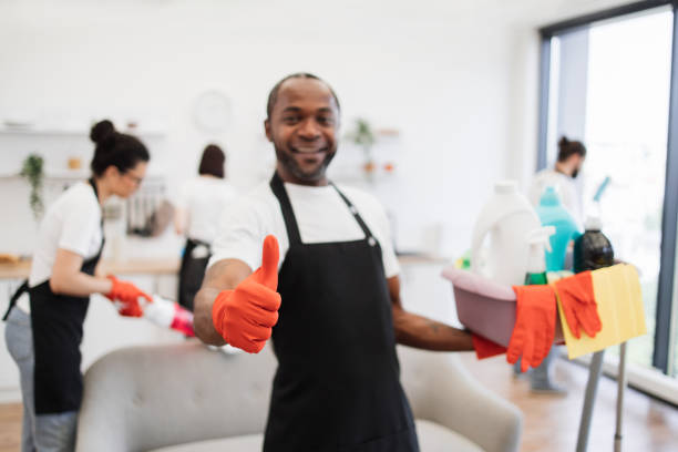 istock African man professional cleaning worker pointing on bucket with detergents. 1939715454