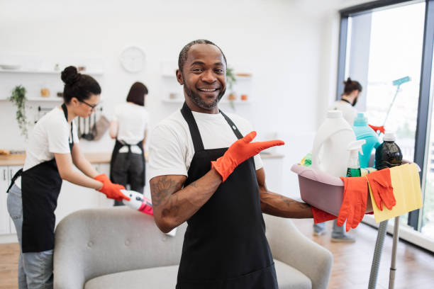 istock American man professional cleaning worker pointing on bucket with detergents. 1939715455