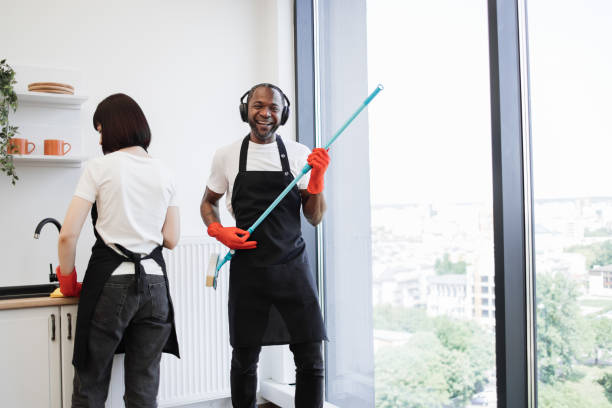 istock African male worker washes windows, having fun while holding mop like guitar. 1939715997