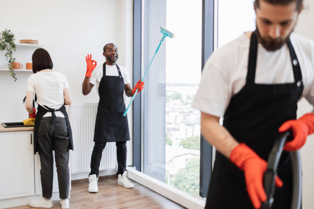 istock Focus on positive African American worker cleaning panoramic window. 1939716807