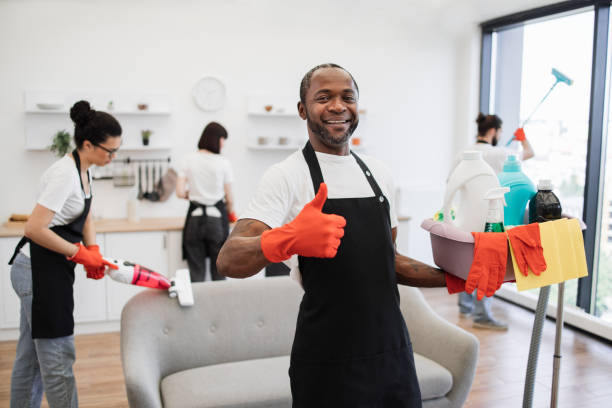 istock African man professional cleaning worker pointing on bucket with detergents. 1939726663