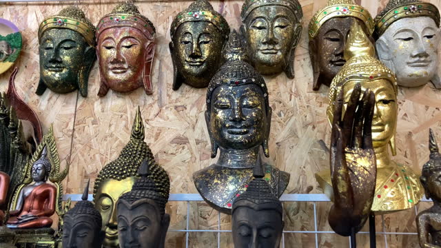 Buddhist face masks hanging in souvenir shop. .Camera slide.