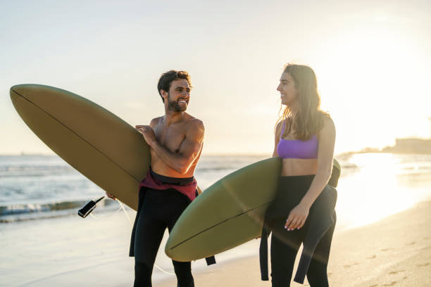 istock A happy surfer couple with surfboards on the beach. 1939745431
