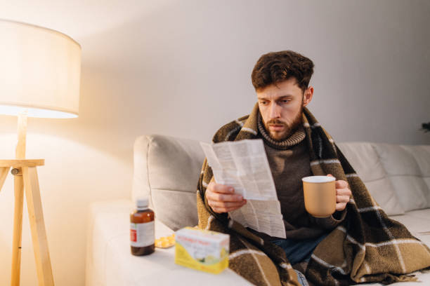 istock A man sick with flu carefully reads the instructions for medicines and drinks anti-cold remedies 1939754596