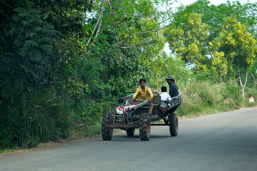 Cambodian people riding on two-wheeled tractor in Siem Reap province, Cambodia.