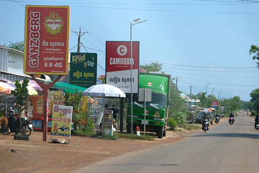 People riding motorcycles in Anlong Veng district, a town in Oddar Meanchey, a province of Cambodia in the remote northwest.