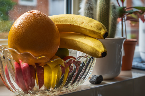 Fresh ripe banana fruit on kitchen windowsill.