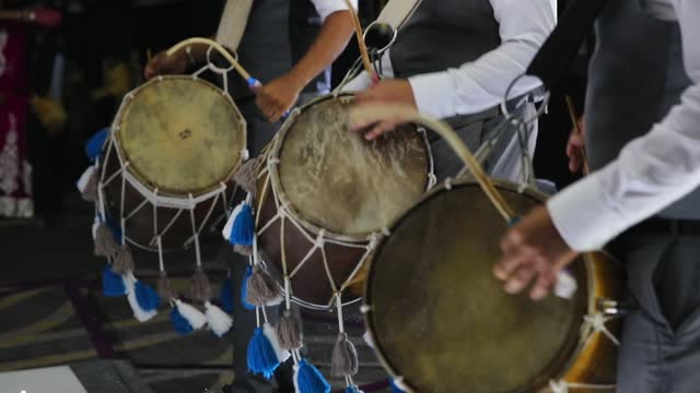 Dynamic trio: Dhol drummers ignite joy at Indian wedding in slow motion.