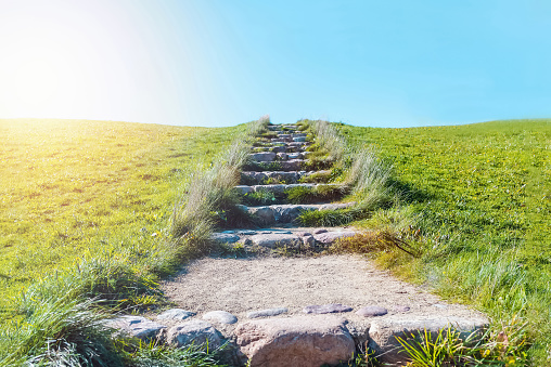 Stone stairs path to the blue sky.Sun, sunlight shining.ladder to the heaven.Next to the summer grass is green.