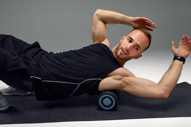 istock Athletic man using a foam roller to relieve sore muscles after a workout. 1939827608