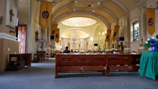 alguns fiéis estão sentados e aguardando o início da santa missa. - churchgoers - fotografias e filmes do acervo