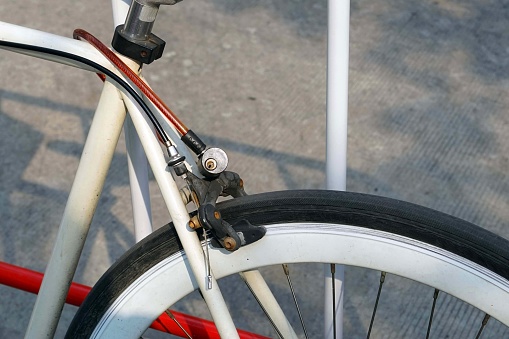 Close up of a bicycle stay stick a barrier traffic by sling cable key locked in a carpark.