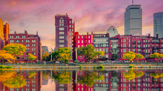 Boston Back Bay Vibrant Skyline, Buildings, and Water Reflections at sunset on the Charles River. Colorful Modern City autumn landscape in New England of America.
