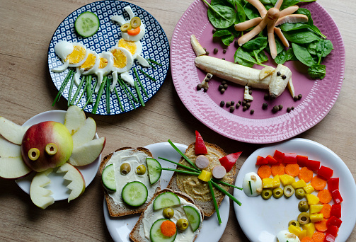 Multi coloured of funny food for child for breakfast. Healthy eating with decoration and creativity and fun in the kitchen. Table top view.