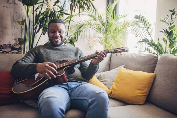 istock Joyful Man Playing Guitar at Home 1939885405