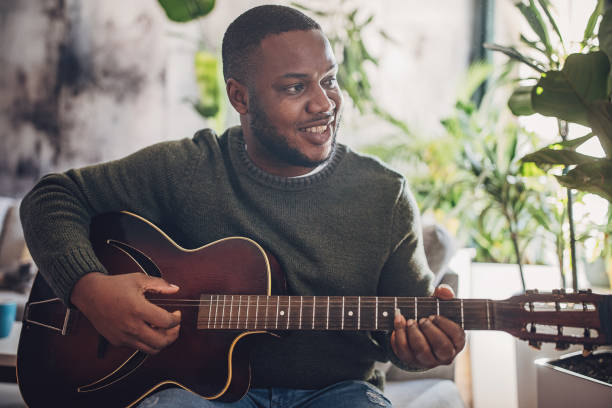 istock Joyful Man Playing Guitar at Home 1939892274