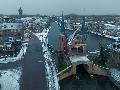 Aerial drone image of the historic Water gate, waterpoort, in Sneek, Friesland, the Netherlands, in winter with light layer of fresh white snow.