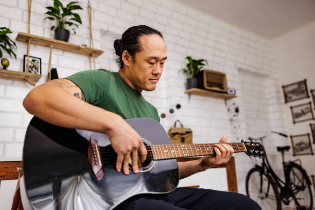 istock Chinese guitarist learning new chords 1939912584