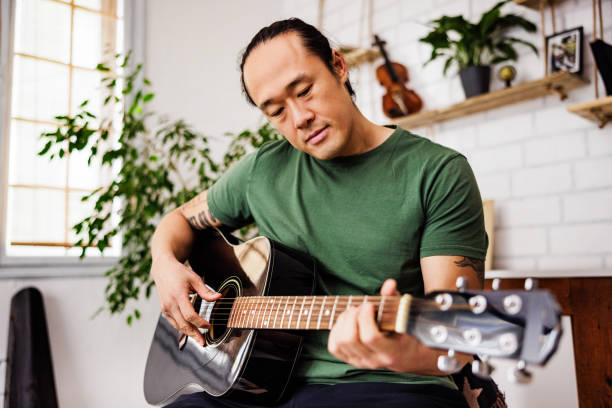 istock Chinese guitarist practice at home 1939912597