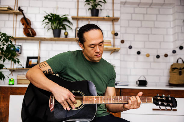 istock Chinese man learning acoustic guitar 1939912598