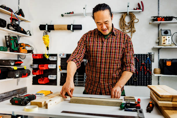 istock Chinese carpenter measures wooden plank 1939913141
