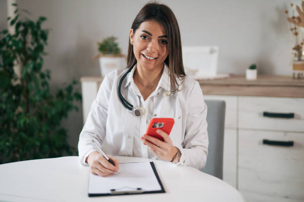 istock Adorable female doctor using smart phone 1939929617