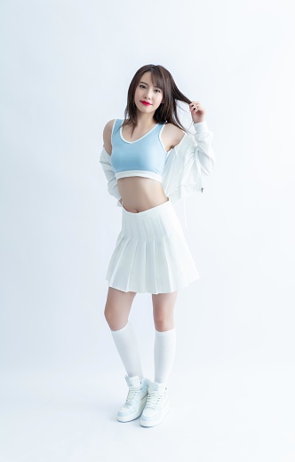 Cheerleader in white pleated skirt and blue sports bra
