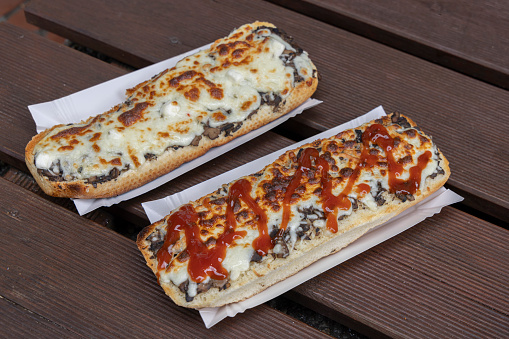 Typical Polish streetfood called Zapiekanka a hot sandwich with mushroon cheese topping and ketchup sauce