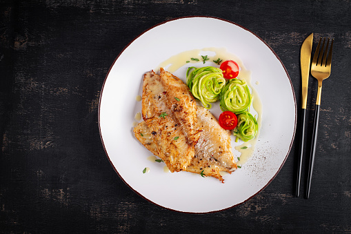 Grilled fish fillet with zucchini pasta. Healthy food concept. Top view, flat lay