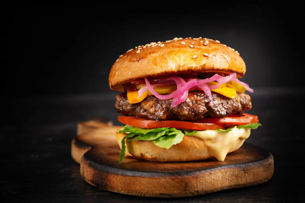 istock Beef hamburger. Sandwich with beef burger, tomatoes, cheese, pickled cucumber and lettuce. Cheeseburger. 1939945955