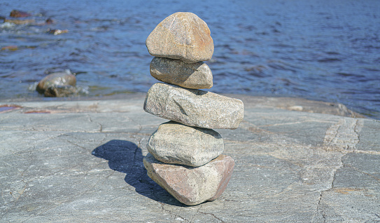 Stacked Rocks balancing, stacking with precision. Stone tower on the shore.