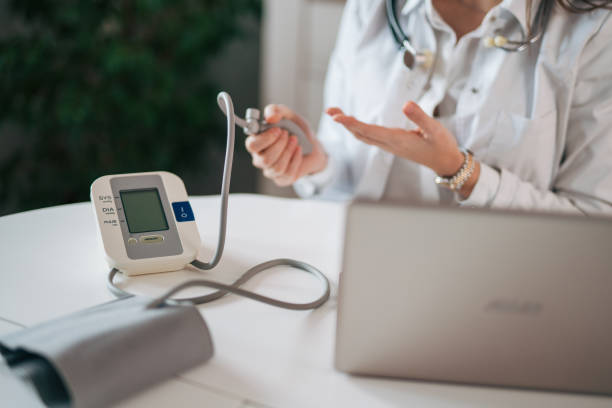 istock Young lady doctor in white medical uniform using computer laptop 1939955907