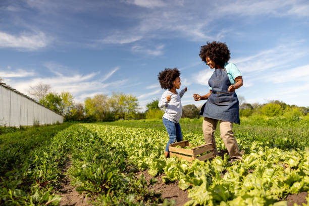 istock Mother and daughter dancing while harvesting vegetables at a plantation 1939972285