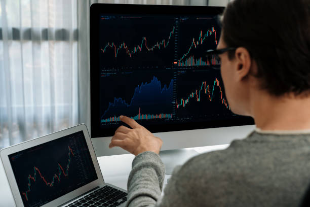 istock Investors pointing interesting stock exchange on pc with laptop. Pecuniary. 1939982674