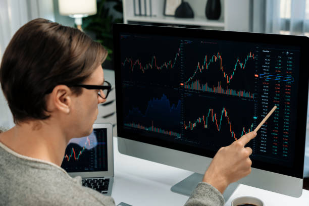 istock Investors pointing interesting stock exchange on pc with laptop. Pecuniary. 1939984817
