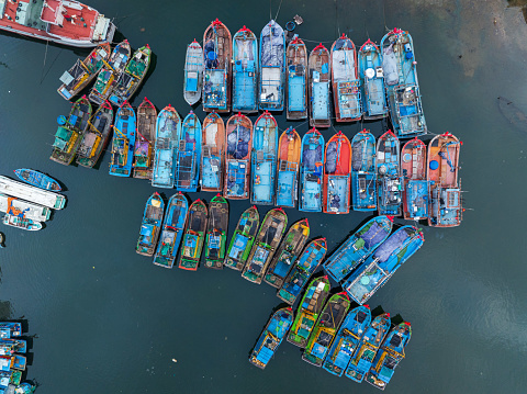 Drone view of fishing boats are nailing side by side on Quy Nhon port, Quy Nhon city, Binh Dinh province, central Vietnam