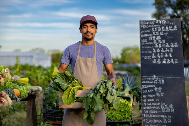 Latin American man selling organic vegetables produced on his plot at a community garden and looking at the camera - sustainable lifestyle concepts