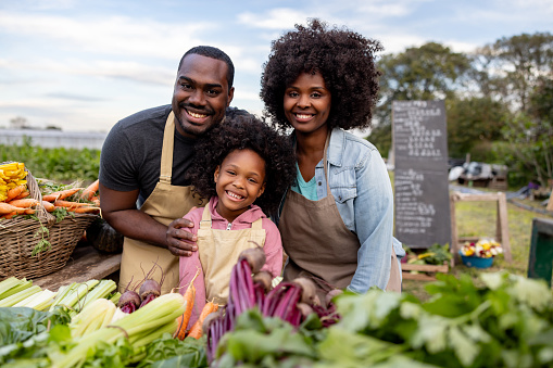 Happy African American family selling their homegrown produce at a Farmer's Market - sustainable lifestyle