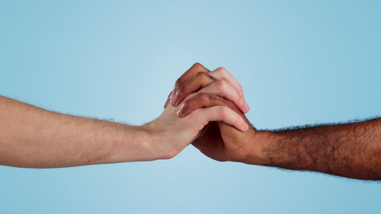Holding hands, love and support in diversity and isolated in studio by blue background. Close up of men, bonding and solidarity in collaboration for community, together and care or kindness in mockup