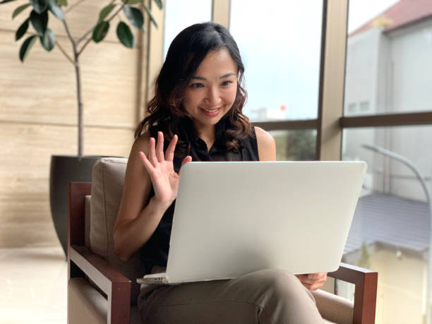 istock Asian Female Entrepreneur Video Conferencing From Lobby Hotel 1940012919