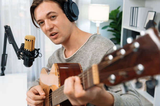 istock Singer with smile face on social media, playing guitar along singing. Pecuniary. 1940013444