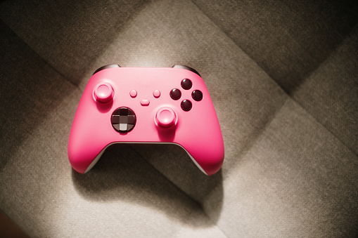 A pink console controller on a sofa
